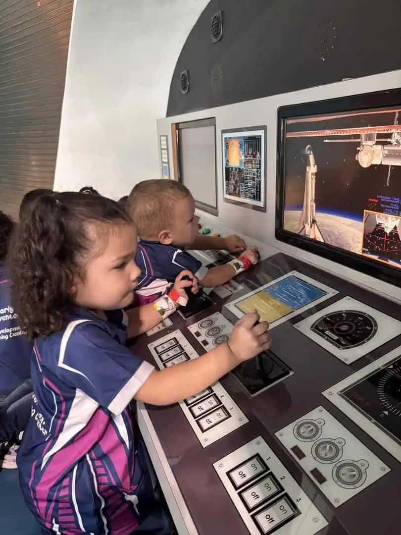 Estudiantes explorando simulador espacial en actividad del calendario escolar